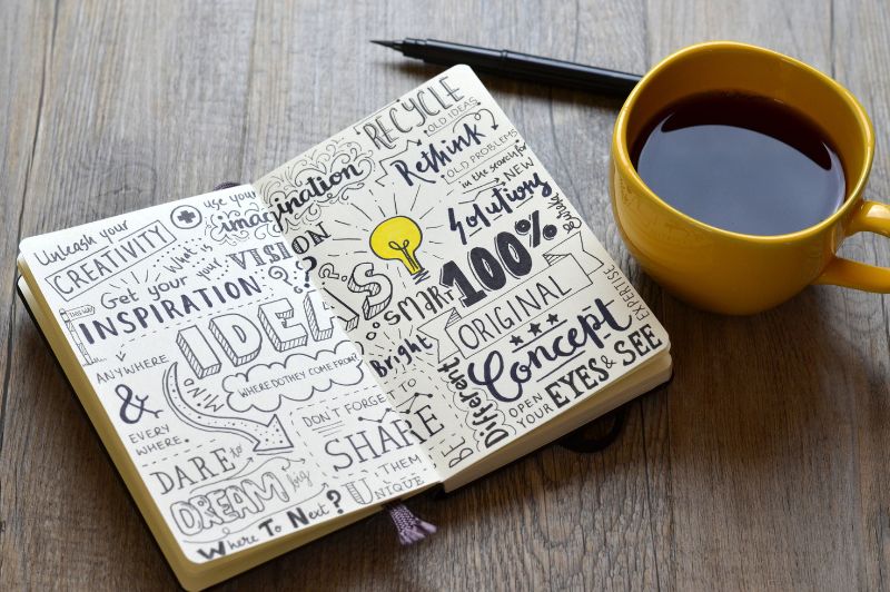 Blog-Inhalte, hier: Bullet Journal mit Zeichnungen, gelbe Kaffeetasse und Bleistift