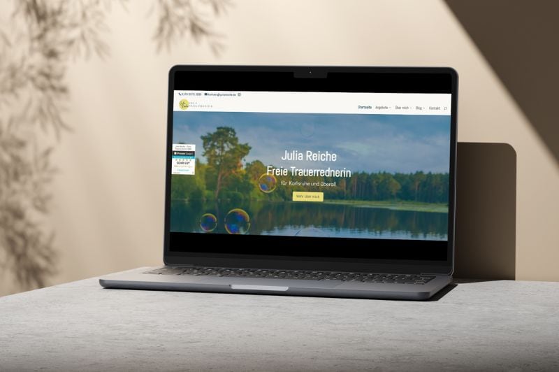 Laptop vor hellbraunem Hintergrund mit Zweigen, hier Mockup der Website von Julia Reiche
