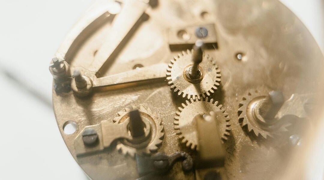 Tools für Webdesign-Projekte, hier Zahnräder eines Uhrwerks in gebürstetem Messing, die teilweise ineinandergreifen